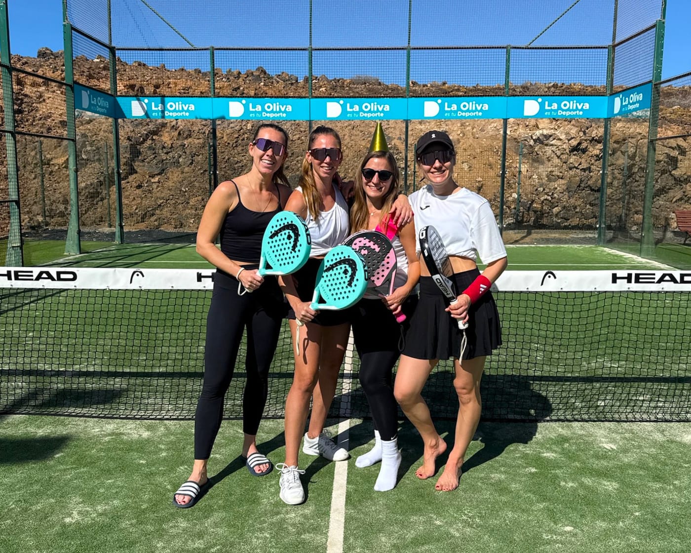 Kleine Trainingsgruppe mit Coach auf dem Padelplatz